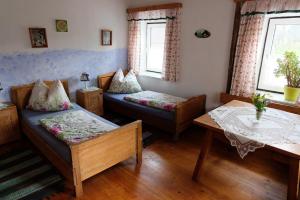 a living room with two beds and a table at Biohof Grissenberger in Abetzdorf