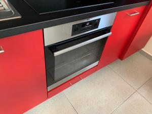 a kitchen with red cabinets and an oven at Terrasses de Malmedy Connecto Duplex 435 & 436 en Studio 336 in Malmedy