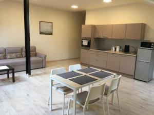 a living room with a table and chairs and a kitchen at Laura in Vilnius