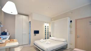 - une chambre blanche avec un lit et un bureau dans l'établissement Casa del Pittore Rialto, à Venise
