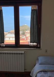 a bedroom with a window with a view of a mountain at Al Sesto City Center in Capo dʼOrlando