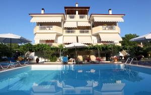 un hotel con piscina frente a un edificio en Villa Valeria Thassos, en Limenas