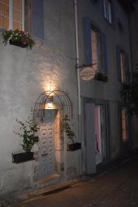 un edificio con una puerta con una luz encendida en L'Ancienne Boulangerie, en Caunes-Minervois