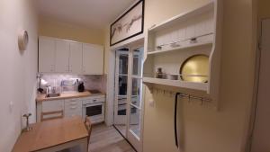 a kitchen with white cabinets and a wooden table at MHC Apartman in Kaposvár