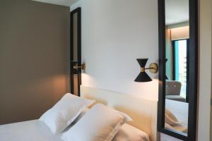 a bedroom with a mirror and a bed with white pillows at Hotel Almirante in Alicante
