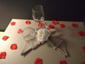 a table with a wine glass and roses on it at Hotel Opuka in Sorriso