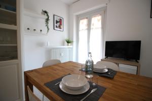 una cocina con una mesa con platos y una botella. en Lovely Panoramic View Apartment - Affitti Brevi Italia en Aosta