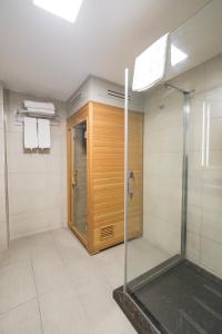 een badkamer met een douche en een glazen deur bij Ramada Plaza By Wyndham Izmir in Izmir
