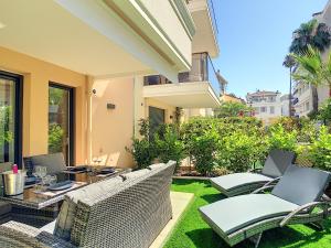 a patio with wicker furniture and a table and chairs at Palm Beach apartment with a pool in the residence in Cannes