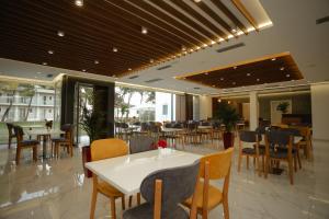 a dining room with tables and chairs in a restaurant at KOMPLEKSI ROYAL in Velipojë