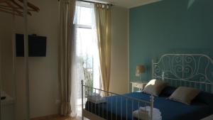 um quarto com uma cama azul e uma janela em Le camere della Nonna em Diano Marina