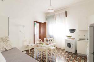 cocina pequeña con mesa y lavadora en Villa Jadì Sottomarina, en Chioggia