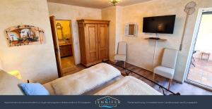 ein Wohnzimmer mit einem Sofa und einem TV an der Wand in der Unterkunft Ferienwohnung Jennifer in Rust
