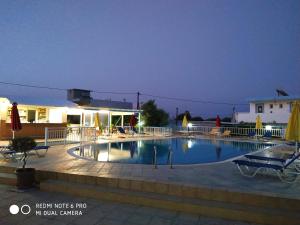 a swimming pool at night in front of a house at Villa Popi Studios in Kefalos
