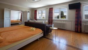 een slaapkamer met een bed en een woonkamer bij Hotel Rotes Kreuz in Arbon