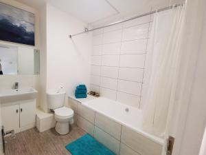 a bathroom with a toilet and a tub and a sink at Highview House Redcar-Seaview Apartments in Redcar +49 photos