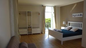 a bedroom with a bed and a couch and a window at Le camere della Nonna in Diano Marina