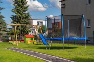 un parque infantil con una red en un patio en Wiatrem Pisane, en Władysławowo