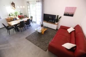 a living room with a red couch and a table at Hisa dobrega pocutja in Kozina