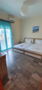 1 dormitorio con 2 camas y ventana en Holiday Dream Aphrodite Apartment, en Mastichari