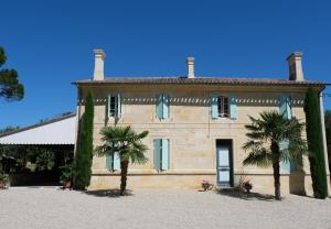 a large building with palm trees in front of it at Domaine Mongiron in Nérigean