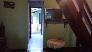 a hallway with a tv on a shelf and a table at Chalet da vila in Angra dos Reis