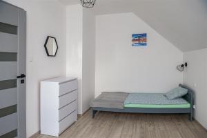 Un dormitorio pequeño con una cama y una cómoda. en Wiatrem Pisane, en Władysławowo