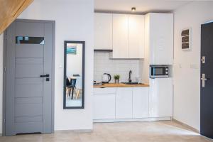 cocina con armarios blancos y encimera en Wiatrem Pisane, en Władysławowo