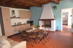 a kitchen with a table and chairs and a fireplace at La Casa Nell'Aia in Monsummano Terme