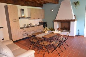 uma cozinha com uma mesa e cadeiras e uma lareira em La Casa Nell'Aia em Monsummano