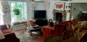Carbis BayにあるCozy Carbence Cottageのリビングルーム(テレビ、ソファ、椅子付)