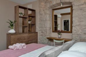 una camera con letto, specchio e scrivania di Lux Dado Igrane a Igrane