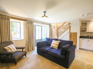 uma sala de estar com um sofá e uma cadeira em Kings Cottage - North em Broad Chalke