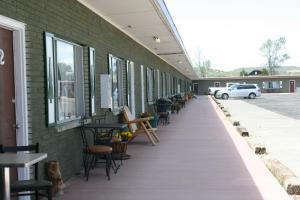 a long hallway with chairs and tables and a car parked on a building at Bryce Zion Inn in Hatch