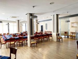 モルシェにあるHotel Costamarの多くのテーブルと椅子が備わるダイニングルーム