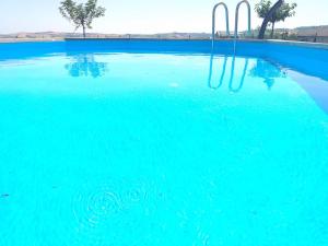 a pool of blue water with a swing in it at fattoria country village in Montecarotto