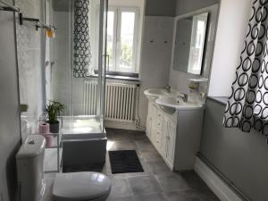 a bathroom with a toilet and a sink and a shower at La maison de la plage in Fécamp