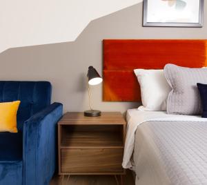 Un dormitorio con una cama y una silla azul. en 4411 Inn & Suites, en Michigan City