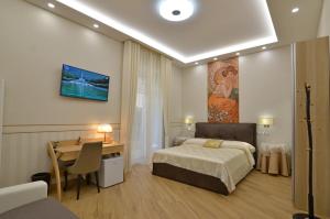 a bedroom with a bed and a desk and a table at CASERTA DELUXE BIS in Caserta