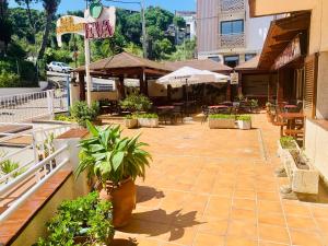 リョレート・デ・マルにあるEva Aparthotelの屋外パティオ(テーブル、椅子、鉢植えの植物付)