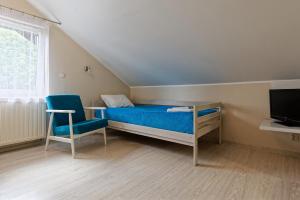 sypialnia z łóżkiem, krzesłem i telewizorem w obiekcie Pensjon Polska w Poznaniu