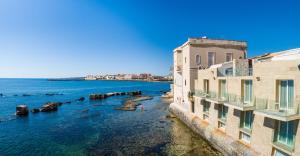 a view of the water between two buildings at Re Dionisio Luxury Suites in Siracusa