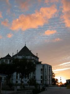 a building with a cross on the roof at sunset at Patio das Margaridas in Óbidos