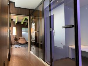 a hallway with a glass door and a chair at La Paix Hôtel Contemporain Brest centre ville in Brest