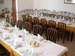 une salle à manger avec des tables et des chaises, des assiettes et de la vaisselle dans l'établissement Patio das Margaridas, à Óbidos