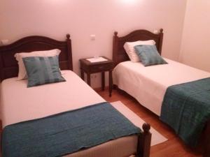 a bedroom with two beds and a night stand at Patio das Margaridas in Óbidos