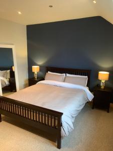 una camera da letto con un letto grande con una parete blu di Feather bed 3 bedroom house a Kinsale