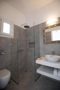 een badkamer met een douche, een toilet en een wastafel bij Flora & Agelos Studios in Chrissi Akti