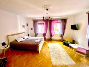 a bedroom with a large bed and pink curtains at Vinyl’s Place in Braşov