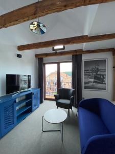 a living room with a blue couch and a table at Willa Oktawia in Niechorze